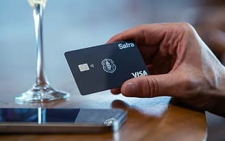 Homem de negócios sorridente usando terno cinza e segurando um tablet