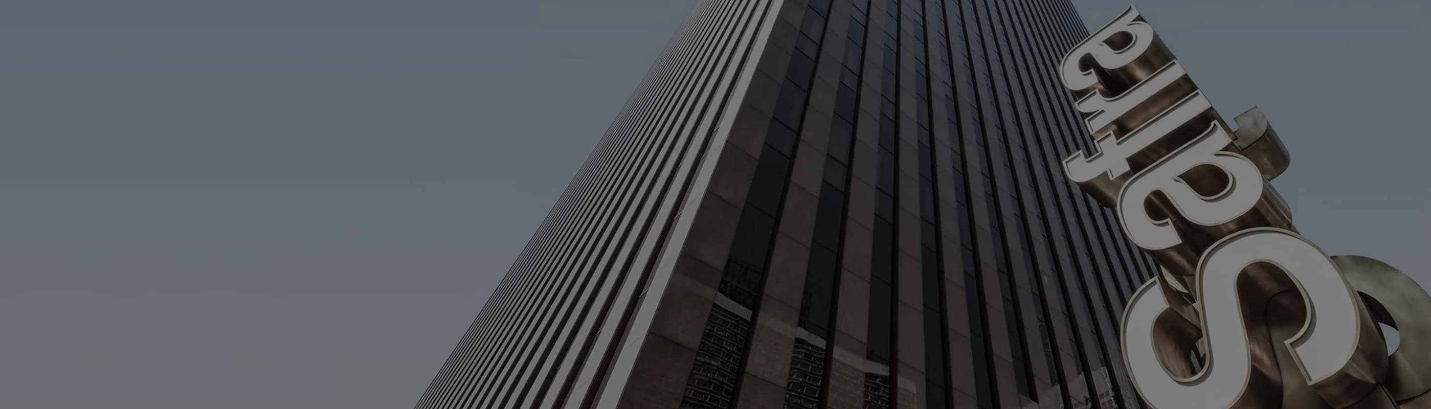 Fachada de prédio com letras Safra em perspectiva urbana.