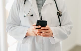 Homem de negócios sorridente usando terno cinza e segurando um tablet