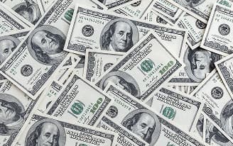 Imagem de várias notas de cem dólares americanos espalhada